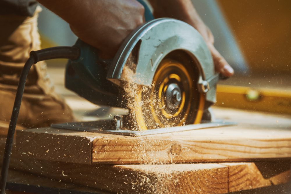 worker using circular saw to cut wood on a job site